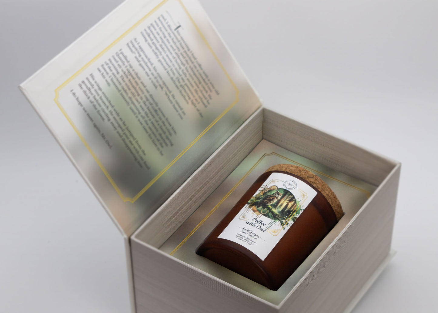 ScentScapes candle with a label featuring an owl, placed in a natural setting with trees and moss in the background inside its storybook box packaging. Unboxing image reveals short story on the inside cover that goes along with the candle scent.
